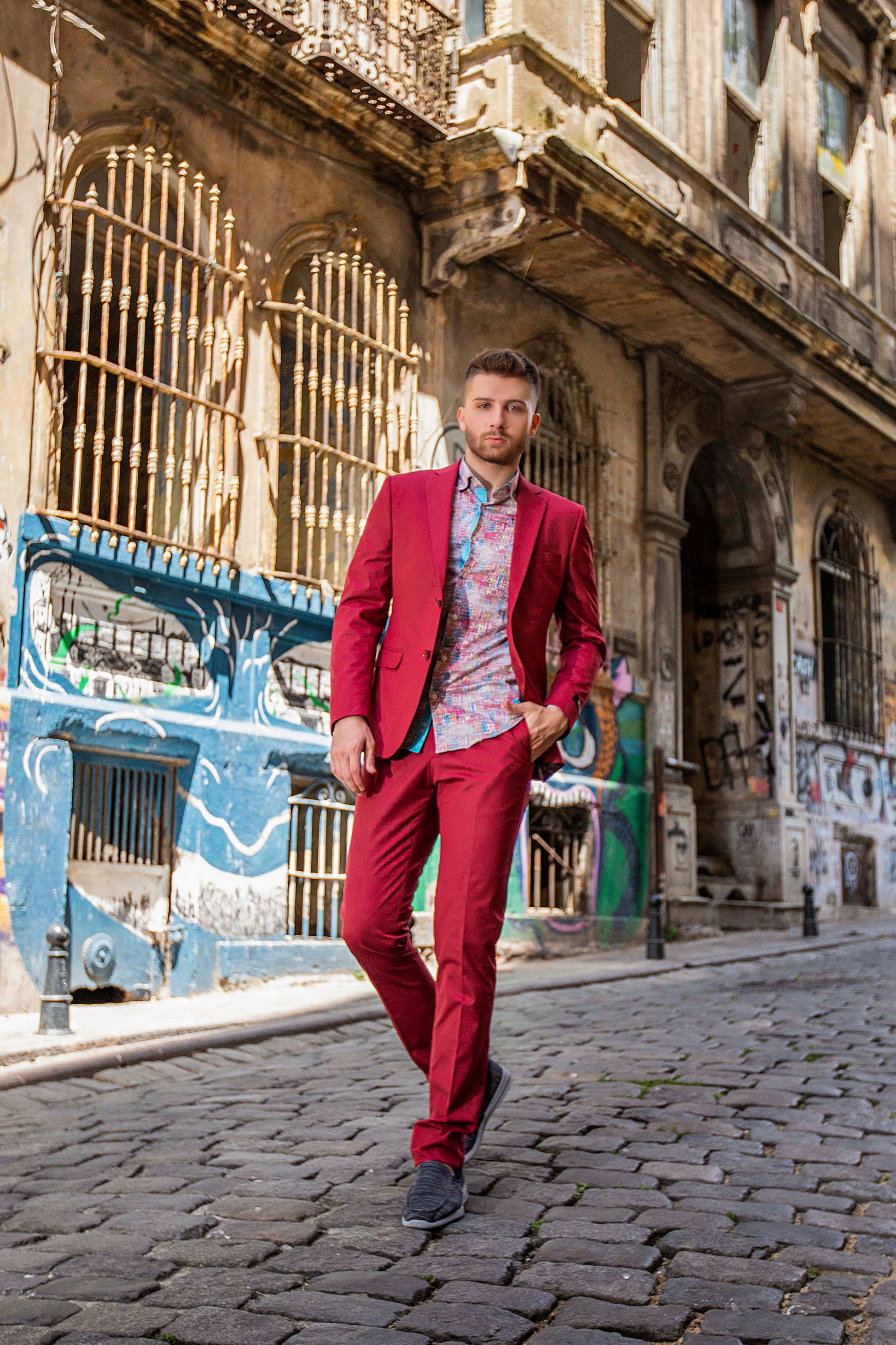 Bold-Red, Slim-Fitted suit made with premium-blended wool, red buttons, and notched lapel. Model is wearing a Valenti, slim, city-skyline-design, dress shirt.